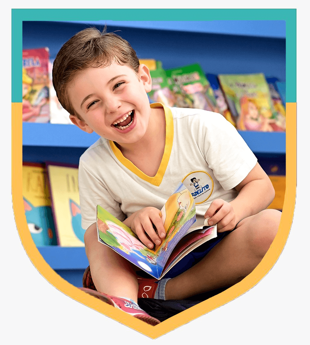 Aluno do Fadelito sorrindo enquanto explora um livro, em uma moldura de escudo